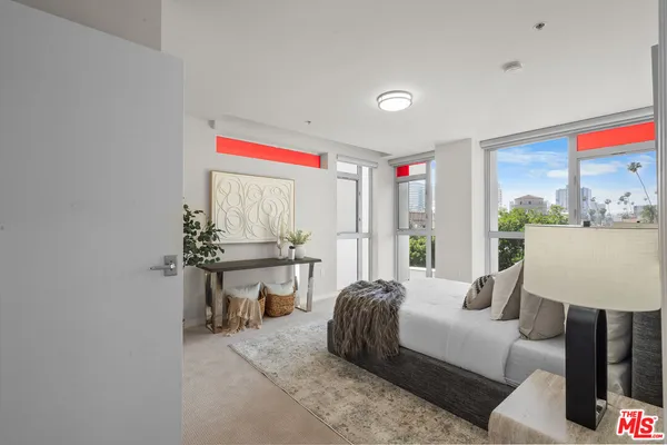 a living room with furniture a large window and a wooden floor