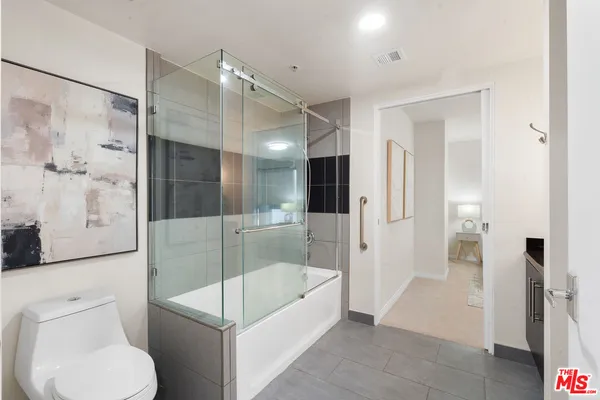 a bathroom with a tub shower and toilet