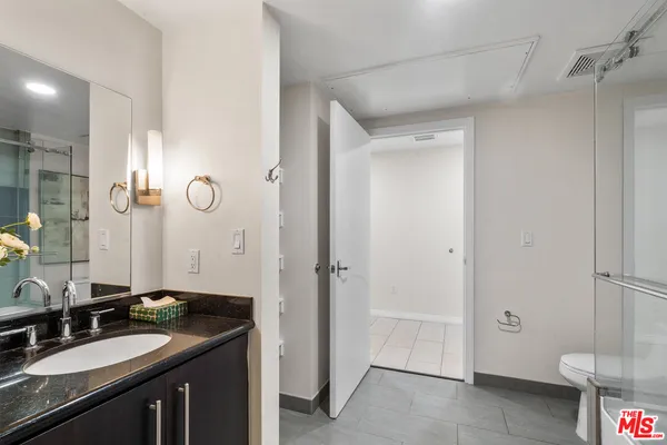 a bathroom with a granite countertop sink toilet and shower