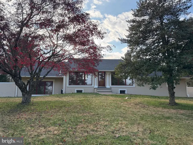 a view of a kitchen with kitchen island white cabinets and stainless steel appliances