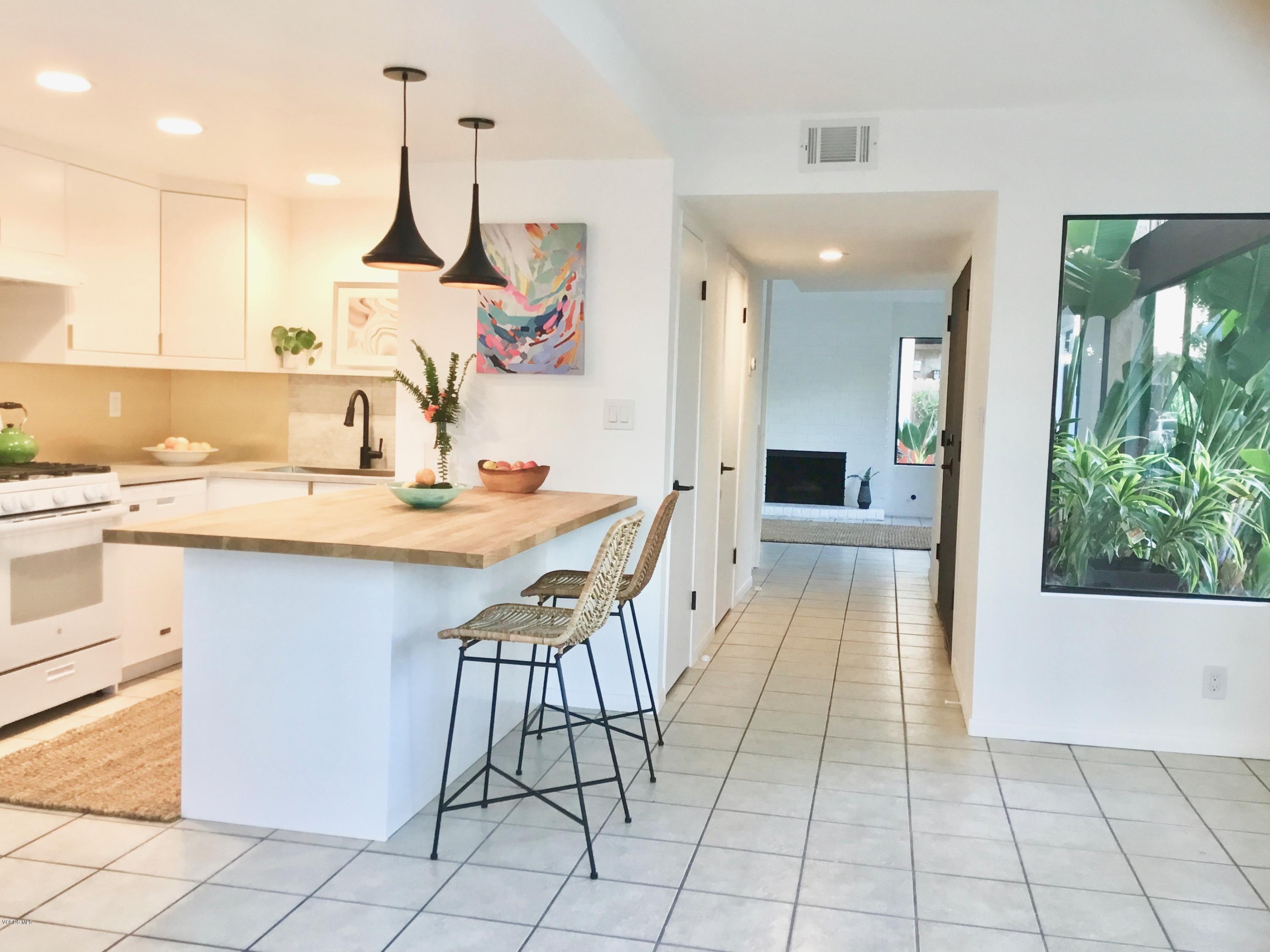 5205 West Wooley Road, Unit 1 Oxnard, CA 93035 - Photo 5 of 21 a kitchen with kitchen island granite countertop a sink and a stove top oven