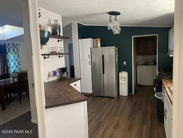 a view of a kitchen with refrigerator and wooden floor