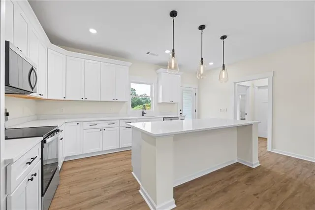 a kitchen with stainless steel appliances sink cabinets and wooden floor