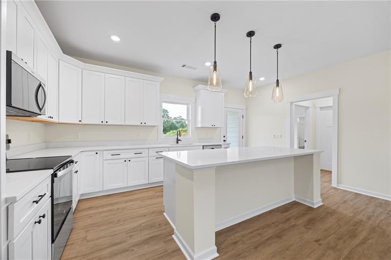 633 Racetrack Road Toccoa, GA 30577 - Photo 13 of 37 a kitchen with stainless steel appliances sink cabinets and wooden floor