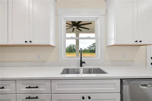 a kitchen with stainless steel appliances white cabinets and a window