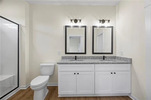 a bathroom with a granite countertop toilet sink and mirror