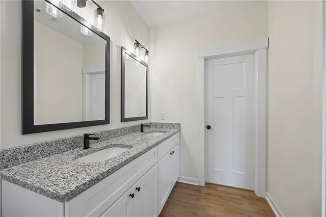 a bathroom with a granite countertop sink and a mirror