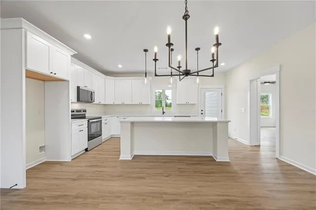 a view of kitchen with wooden floor and electronic appliances