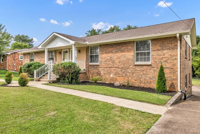 a front view of a house with a yard and potted plants