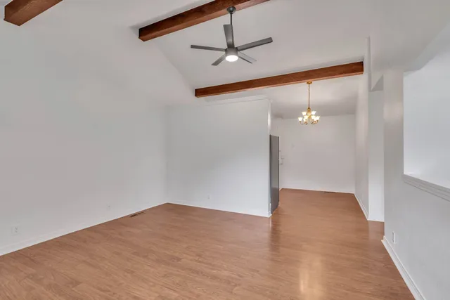 a view of a big room with wooden floor and a ceiling fan