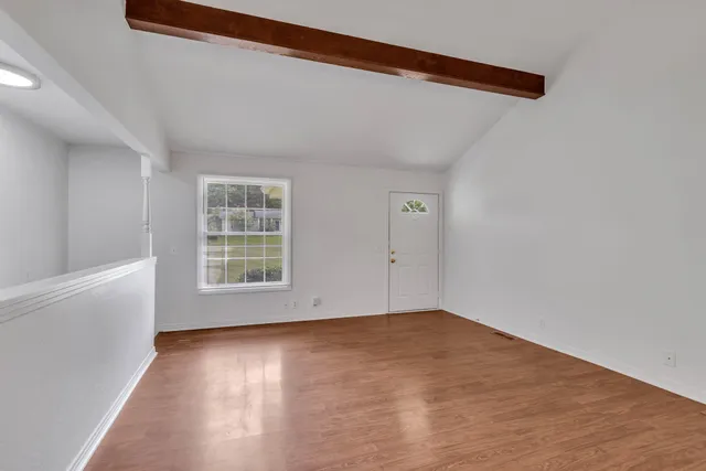 wooden floor in an empty room with a window
