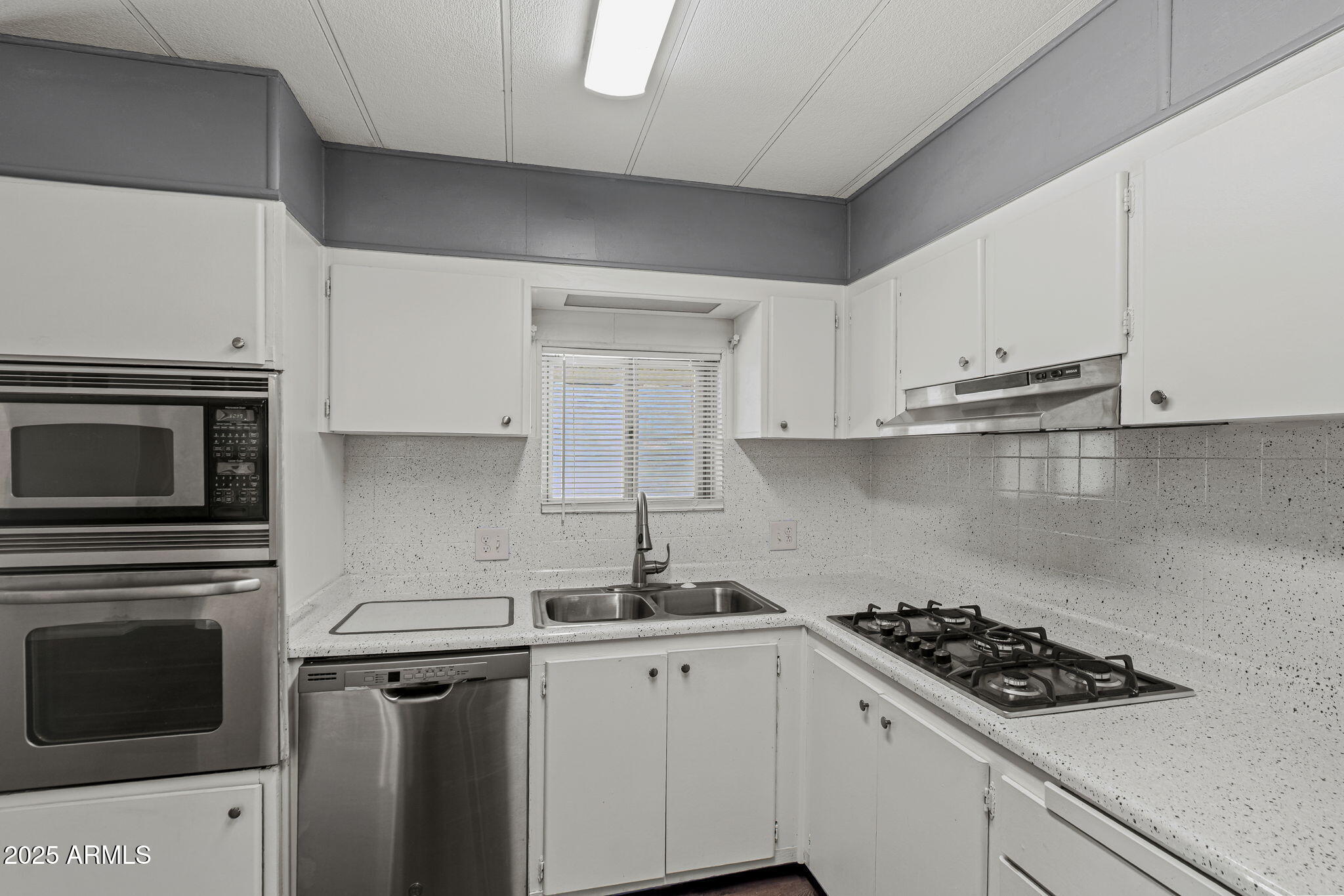 201 South Greenfield Road, Unit 207 Mesa, AZ 85206 - Photo 3 of 50 a kitchen with white cabinets stainless steel appliances and sink