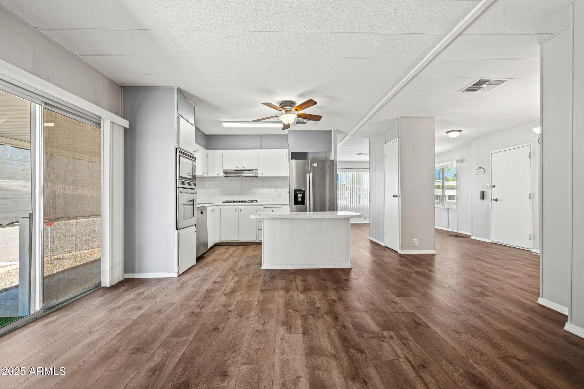 201 South Greenfield Road, Unit 207 Mesa, AZ 85206 - Photo 44 of 50 a large kitchen with white cabinets and wooden floor