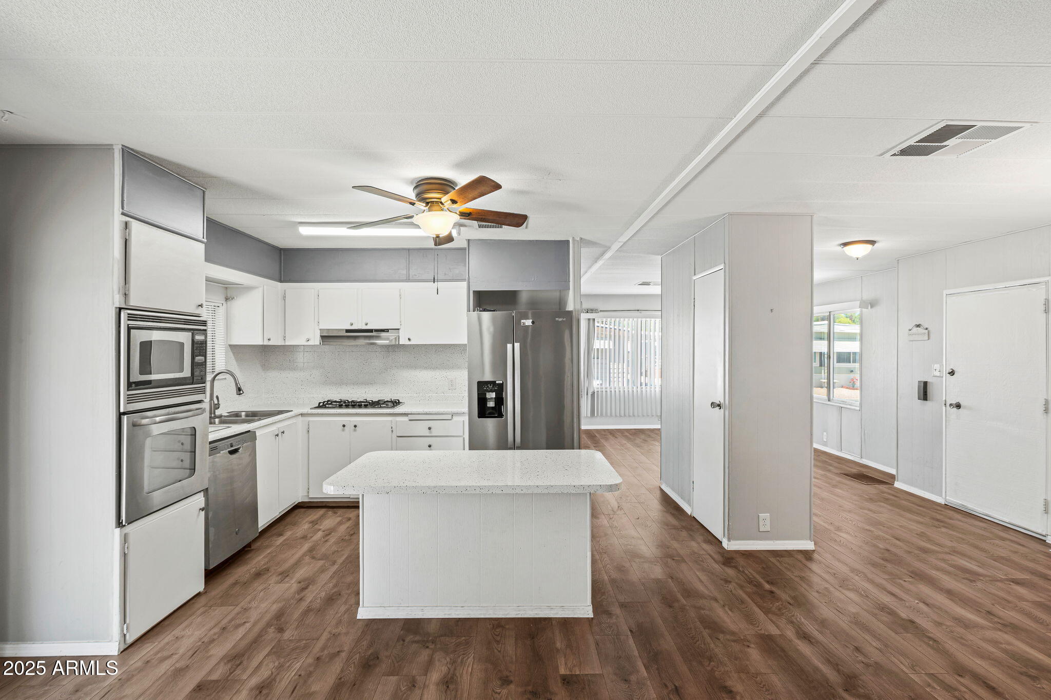 201 South Greenfield Road, Unit 207 Mesa, AZ 85206 - Photo 48 of 50 a large kitchen with cabinets wooden floor and stainless steel appliances