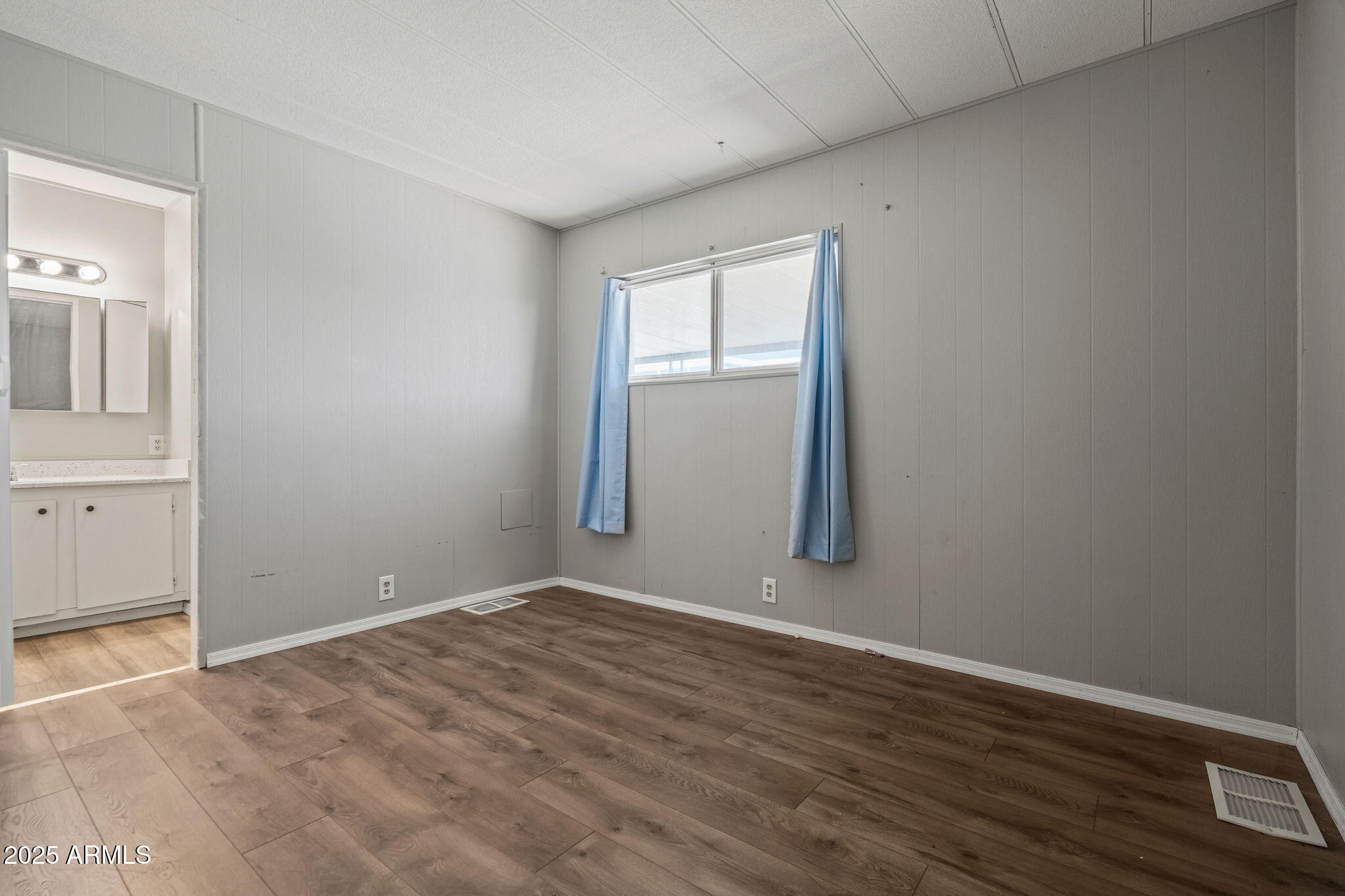 201 South Greenfield Road, Unit 207 Mesa, AZ 85206 - Photo 8 of 50 an empty room with wooden floor and windows