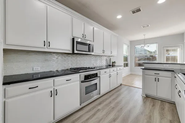a kitchen with stainless steel appliances a sink a stove and cabinets