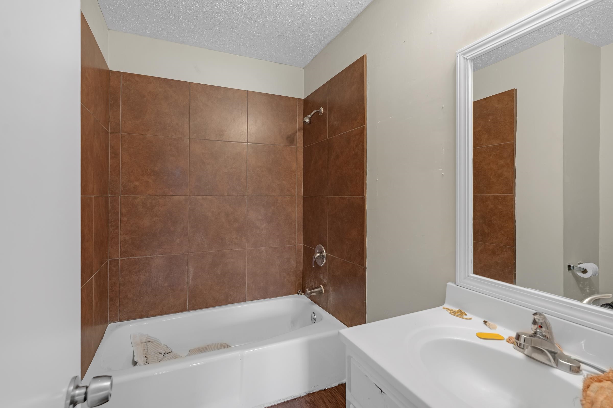 6128 Raintree Drive Memphis, TN 38115 - Photo 16 of 30 Full bathroom featuring shower / washtub combination, a textured ceiling, and vanity