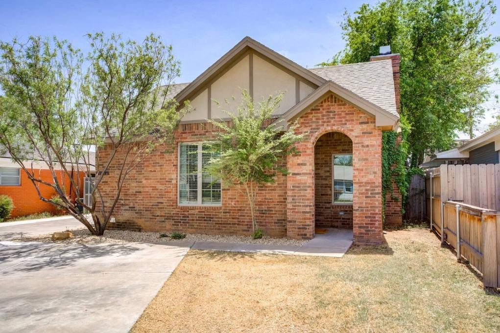 3107 33rd Street, Unit 1 Lubbock, TX 79410 - Photo 1 of 22 a view of a house with wooden fence next to a yard