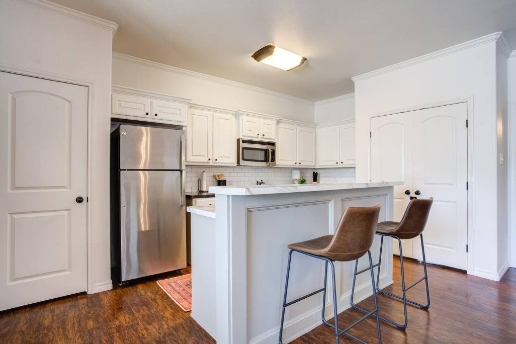 3107 33rd Street, Unit 1 Lubbock, TX 79410 - Photo 12 of 22 a kitchen with stainless steel appliances a refrigerator stove microwave and cabinets