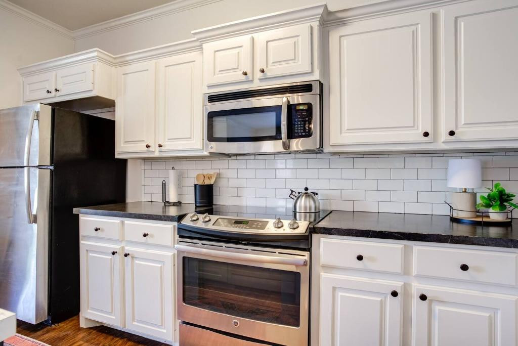 3107 33rd Street, Unit 1 Lubbock, TX 79410 - Photo 13 of 22 a kitchen with white cabinets and black appliances