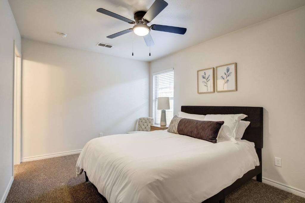 3107 33rd Street, Unit 1 Lubbock, TX 79410 - Photo 17 of 22 a bedroom with a large bed and a ceiling fan