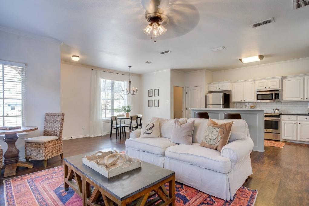 3107 33rd Street, Unit 1 Lubbock, TX 79410 - Photo 4 of 22 a living room with furniture a wooden floor and a chandelier