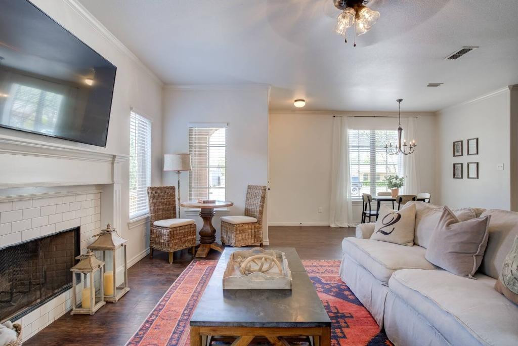3107 33rd Street, Unit 1 Lubbock, TX 79410 - Photo 8 of 22 a living room with furniture a large window and a fireplace