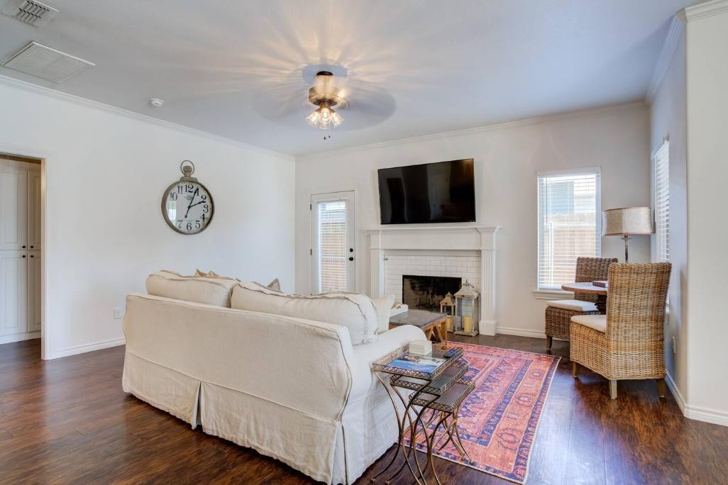 3107 33rd Street, Unit 1 Lubbock, TX 79410 - Photo 9 of 22 a living room with furniture a fireplace and a flat screen tv