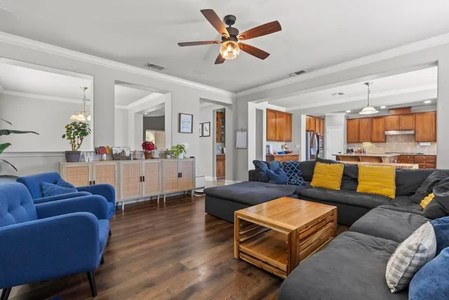 a living room with furniture kitchen view and a large window