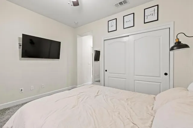 a bedroom with a bed and a flat screen tv