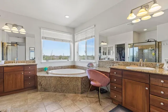 a spacious bathroom with a granite countertop tub sink and a mirror