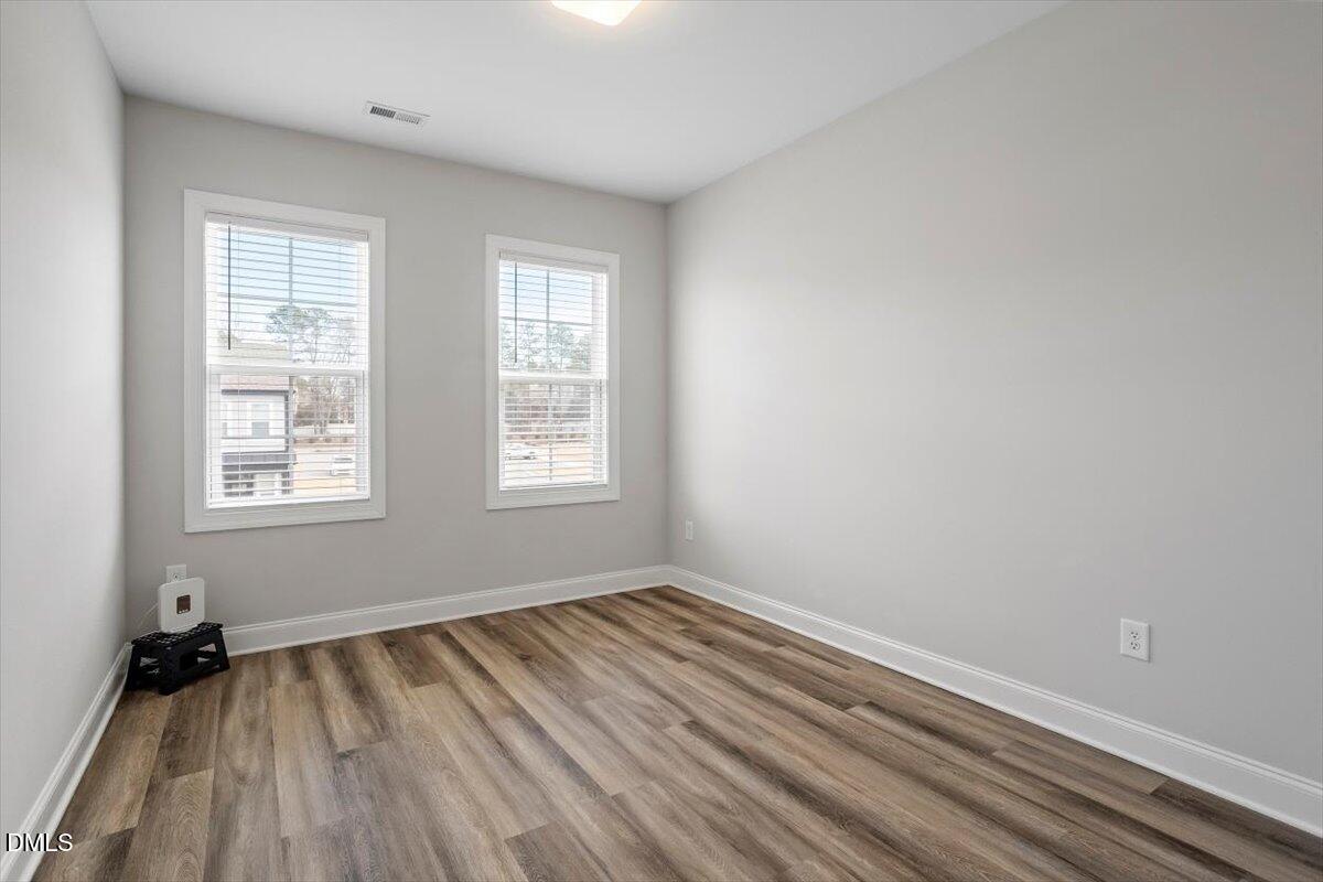 603 Marshskip Way Rolesville, NC 27571 - Photo 24 of 28 an empty room with wooden floor and windows