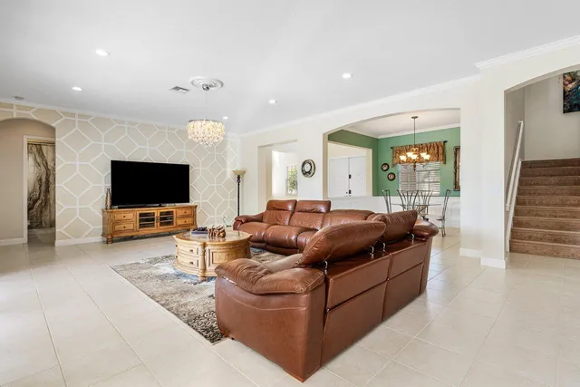 a kitchen with stainless steel appliances kitchen island granite countertop a dining table chairs refrigerator and sink