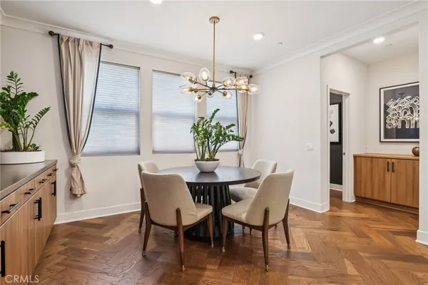 a dining room with furniture potted plants and wooden floor