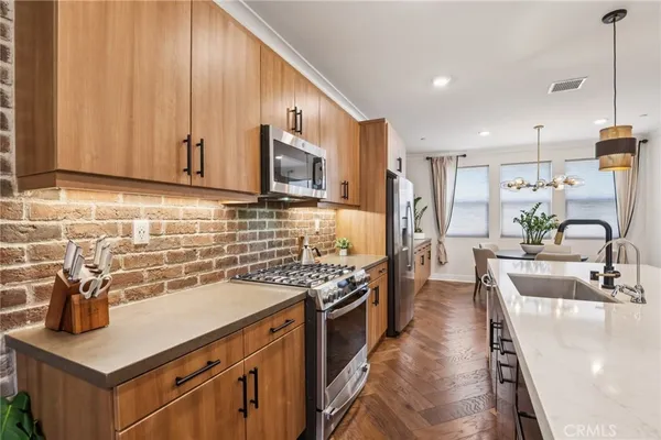a kitchen with stainless steel appliances granite countertop a sink stove and refrigerator