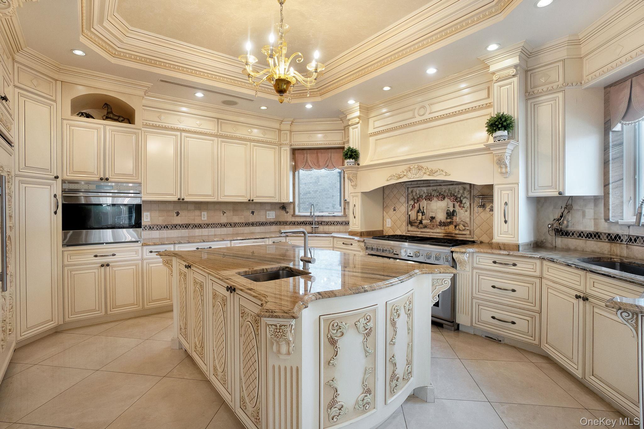 181-30 Tudor Road Queens, NY 11432 - Photo 19 of 46 Kitchen featuring cream cabinetry, light stone counters, light tile patterned floors, recessed lighting, and stainless steel appliances