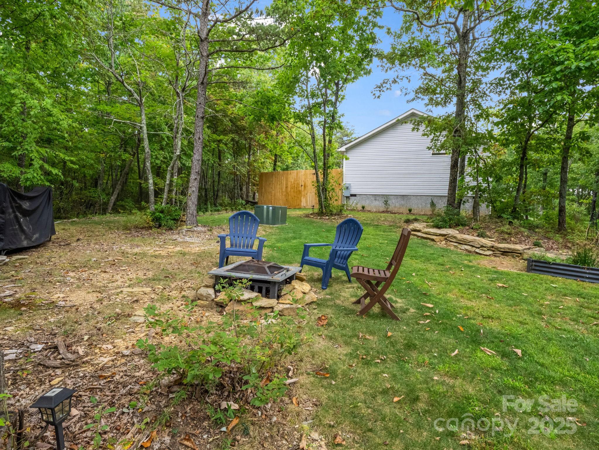 343 East Marshall Ridge Road Hendersonville, NC 28792 - Photo 27 of 44 a view of a backyard with chairs and a fire pit