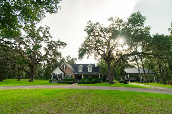 a front view of a house with a yard and trees
