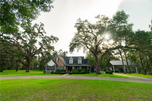 a front view of a house with a yard and trees