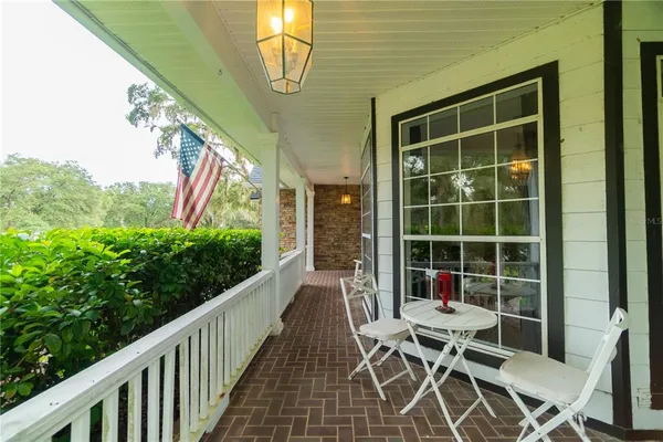 a balcony with chairs and a potted plant