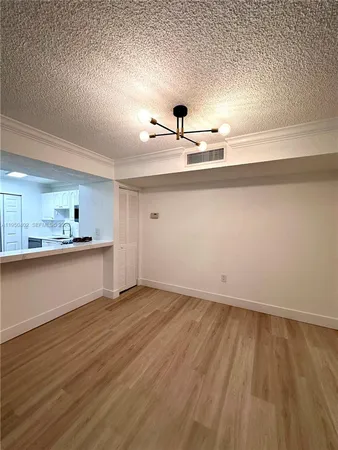 a view of a kitchen with a sink wooden cabinets and a refrigerator