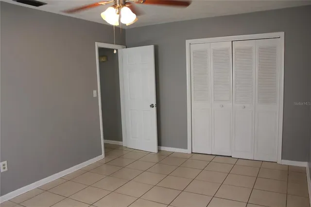 an empty room and chandelier fan