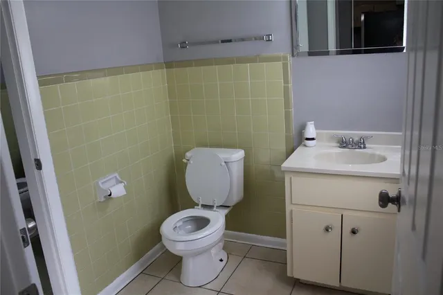 a bathroom with a toilet sink vanity and mirror