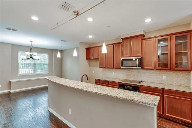a kitchen with stainless steel appliances granite countertop a sink a stove top oven a counter space and cabinets