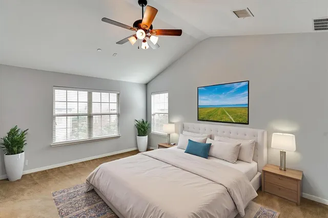 a bedroom with bed tv and a window