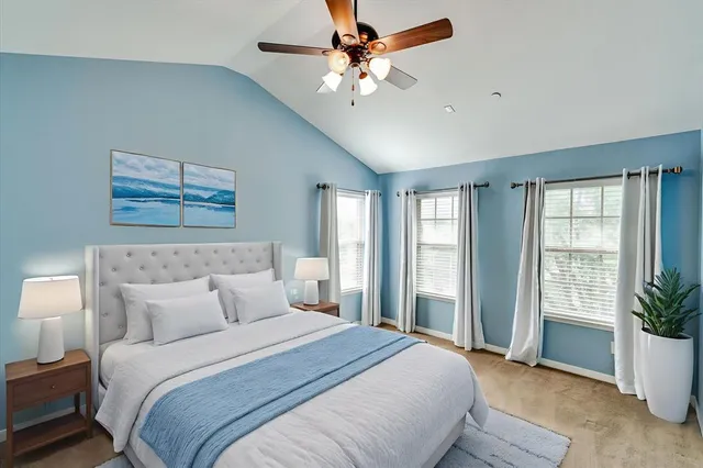 a bedroom with a large bed and a potted plant