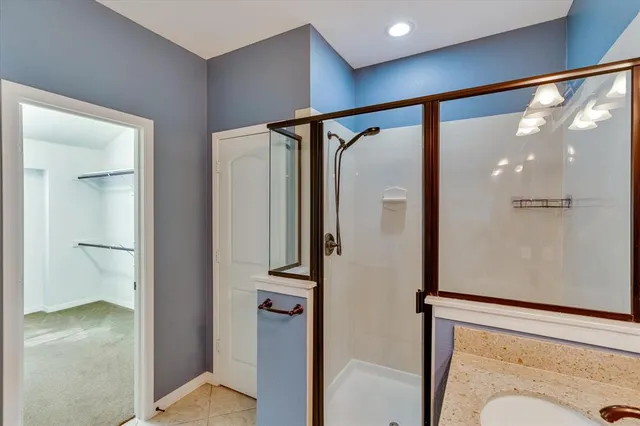 a bathroom with a glass shower door and a sink