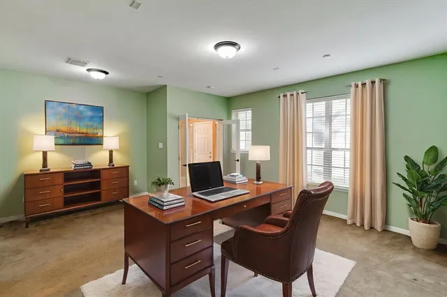 a view of a workspace with furniture and a window