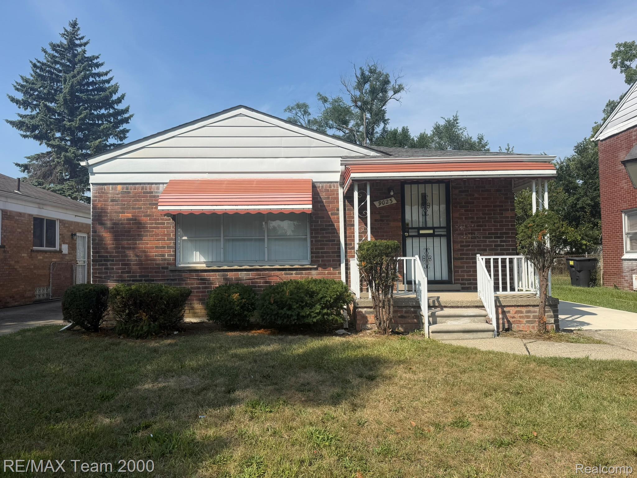 9023 Evergreen Road Detroit, MI 48228 - Photo 2 of 21 Charming brick ranch home featuring a covered front porch with white railings, large front-facing window, and a gabled roofline
