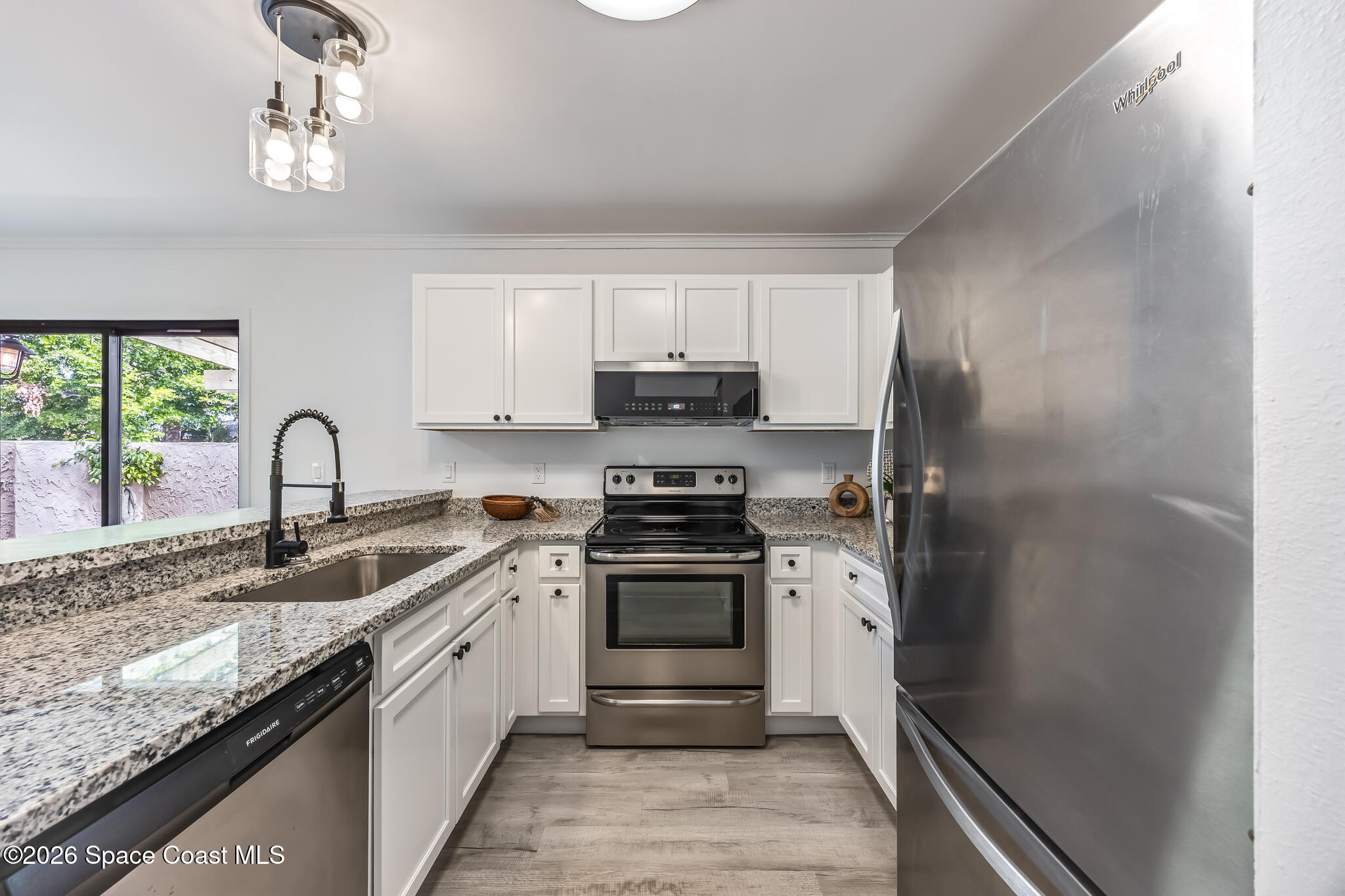 1411 Sheafe Avenue Northeast, Unit 101 Palm Bay, FL 32905 - Photo 10 of 24 a kitchen with stainless steel appliances granite countertop a sink stove and refrigerator